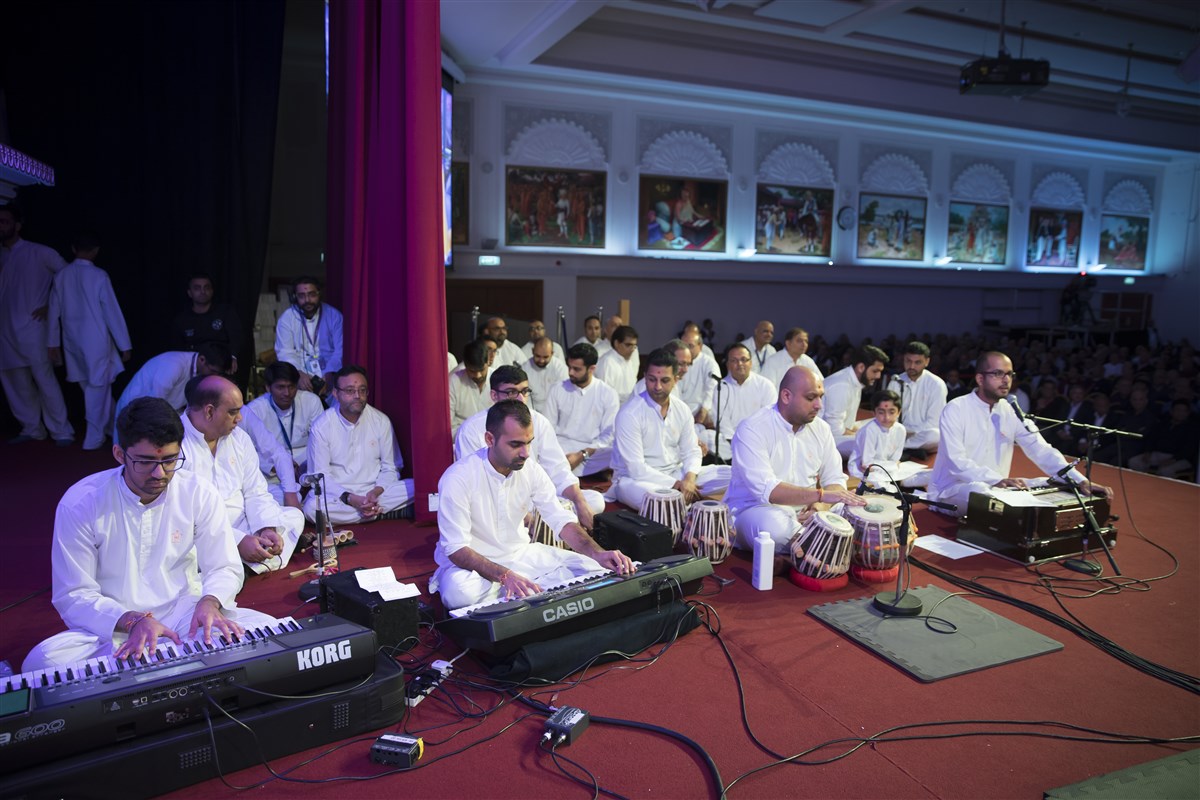 Devotees from around the UK collectively sing and perform in Swamishri's puja