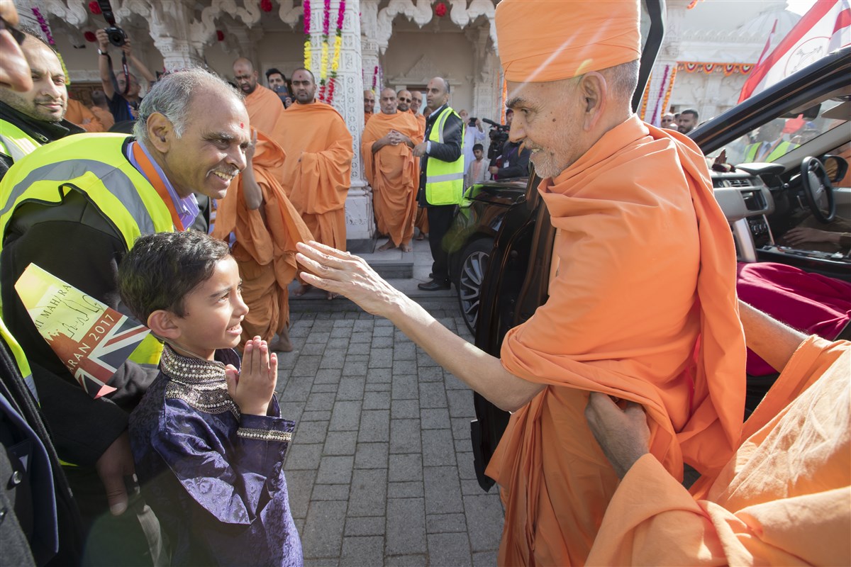 Swamishri blesses a child upon arriving at the Mandir