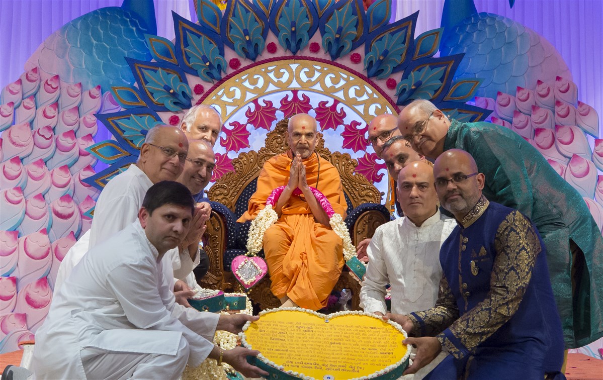 Lead volunteers of BAPS UK mandirs honour Swamishri with a decorative garland