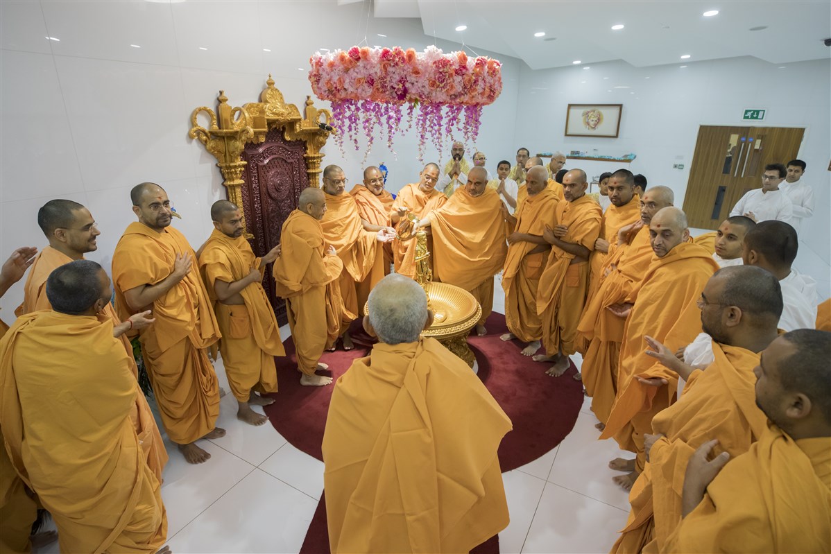 Swamishri observes as swamis collectively perform the abhishek of Shri Nilkanth Varni
