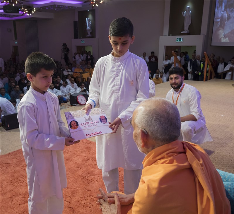 Children invite Swamishri to the evening assembly