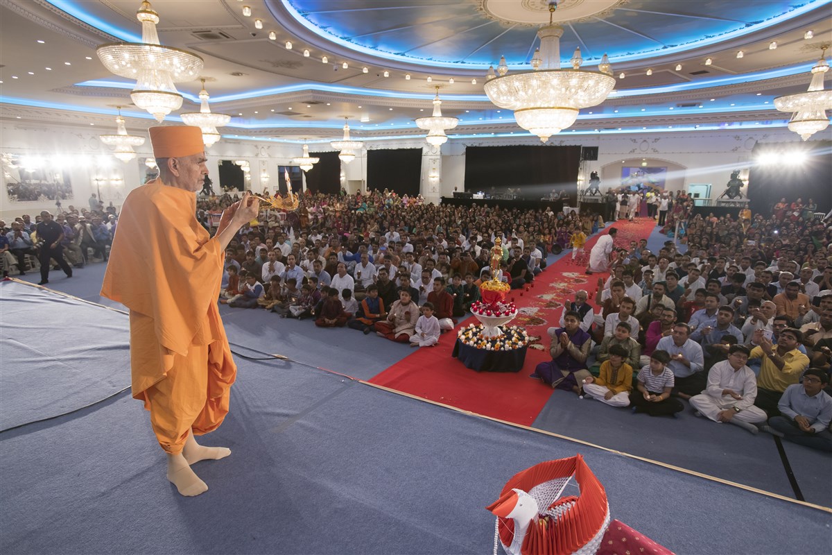 Devotees participate in the arti with Swamishri