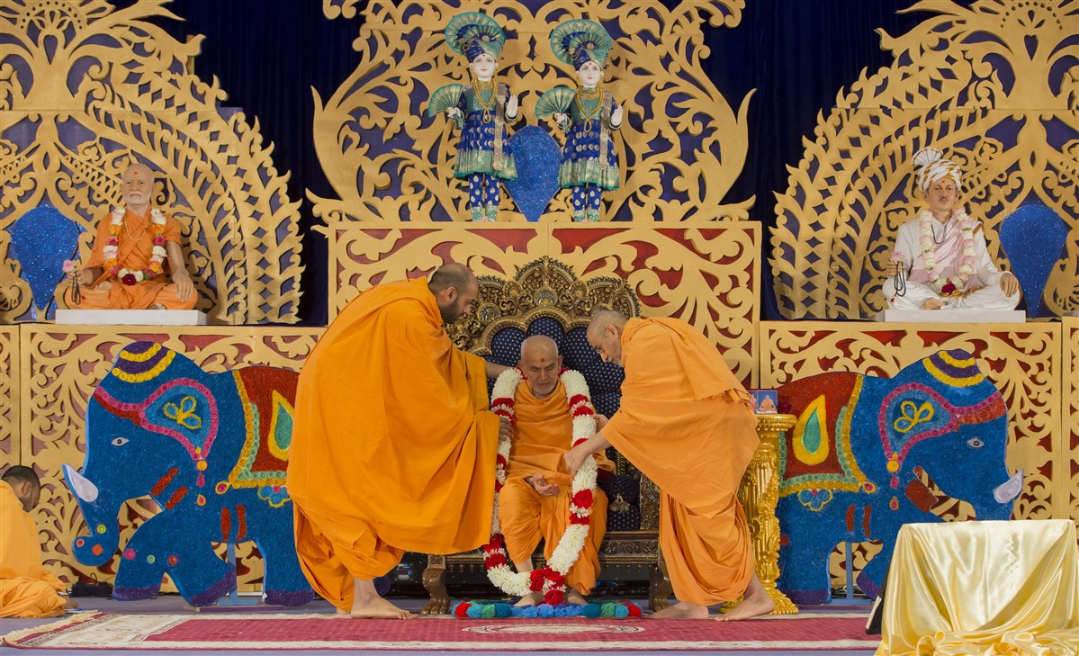 Swamis honour Swamishri with a garland of flowers