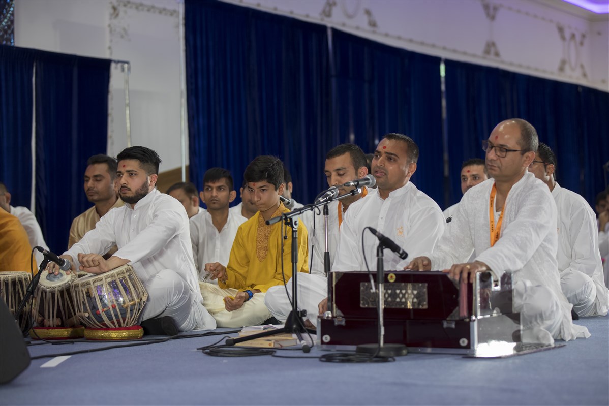 Devotees sing kirtans during Swamishri's puja