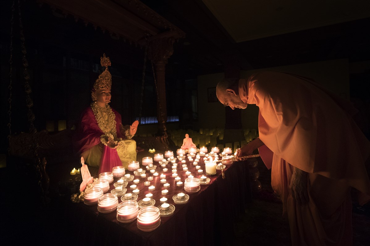 ... by lighting a divo before the murti of Bhagwan Swaminarayan