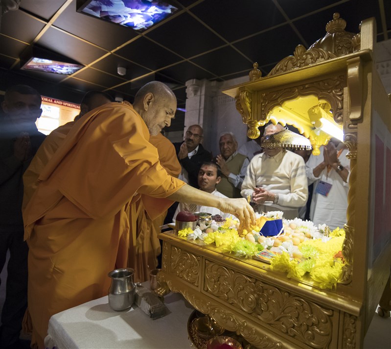 Swamishri honours the mahapuja with flower petals