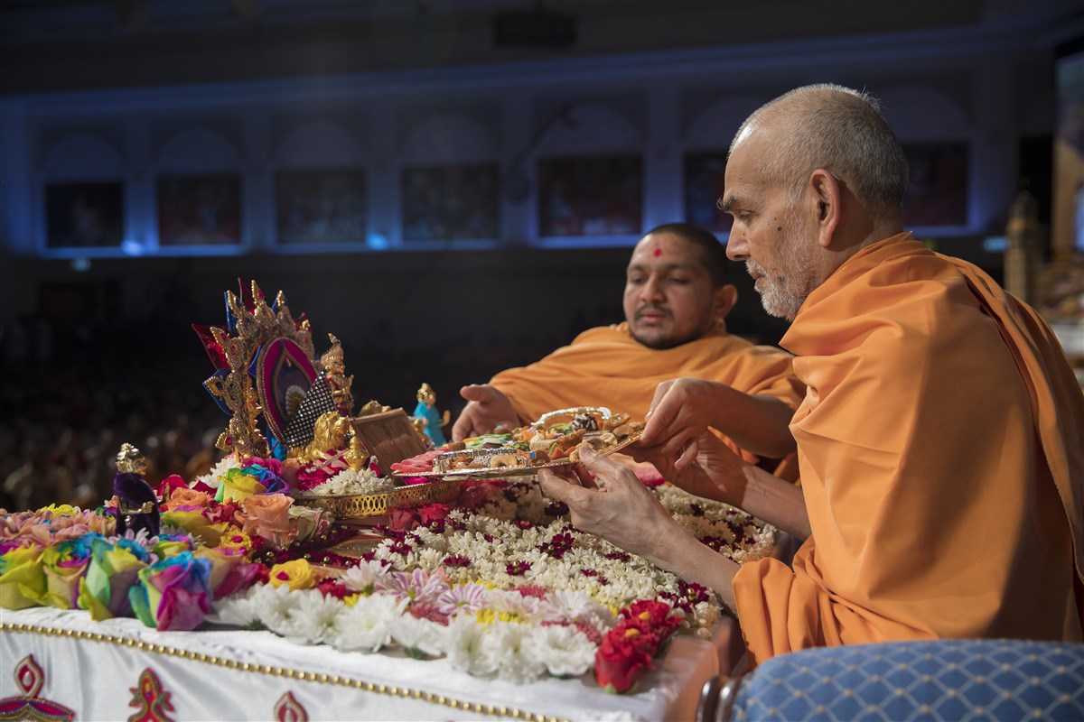 Swamishri offers thal to the murtis in his puja