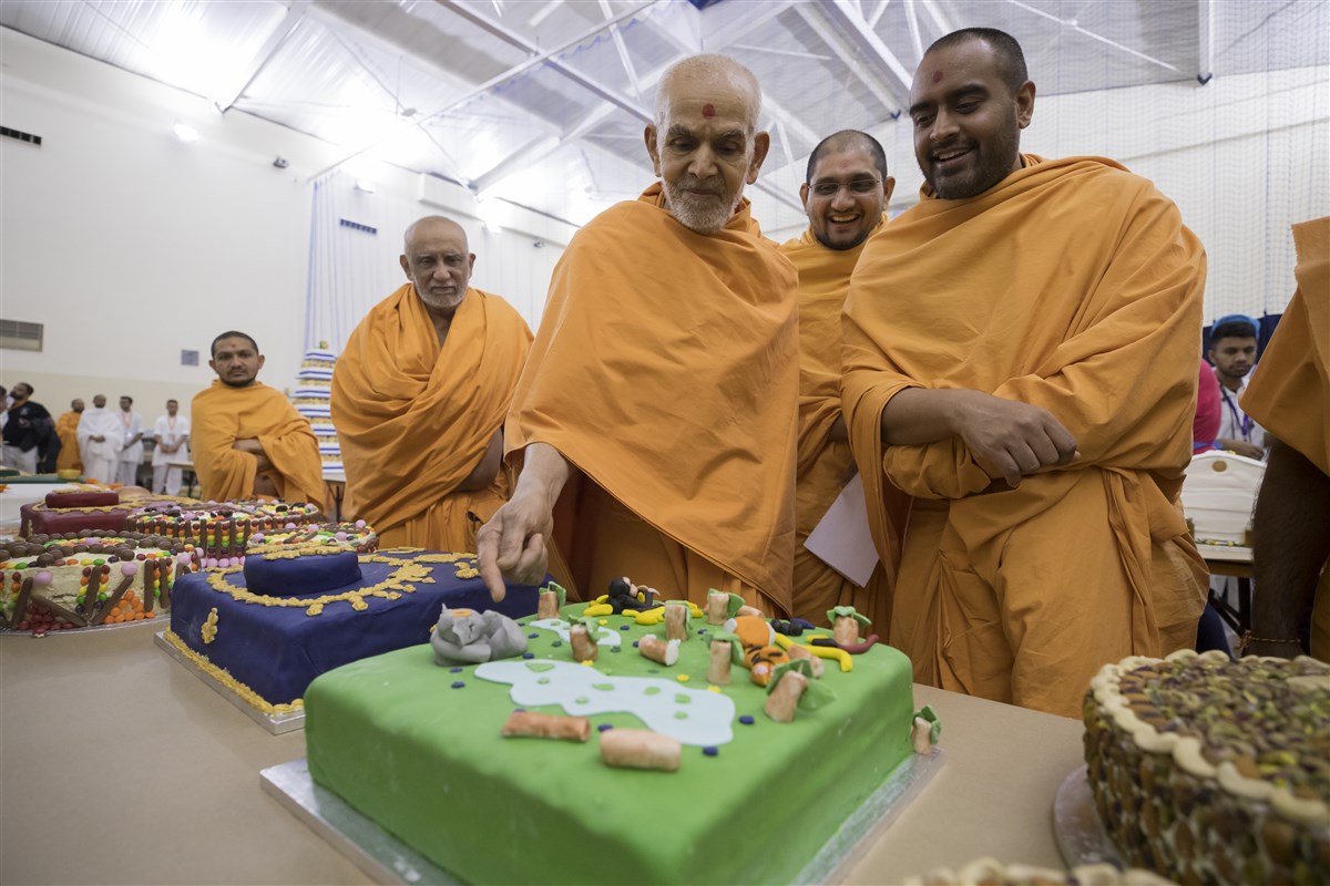 Swamishri observes a decorative cake for the annakut