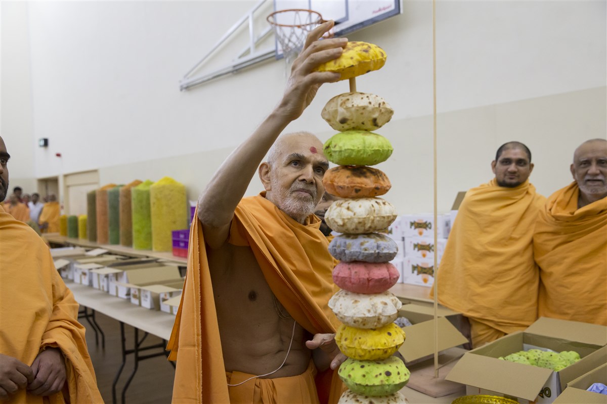 Swamishri completes a decorative offering for the annakut