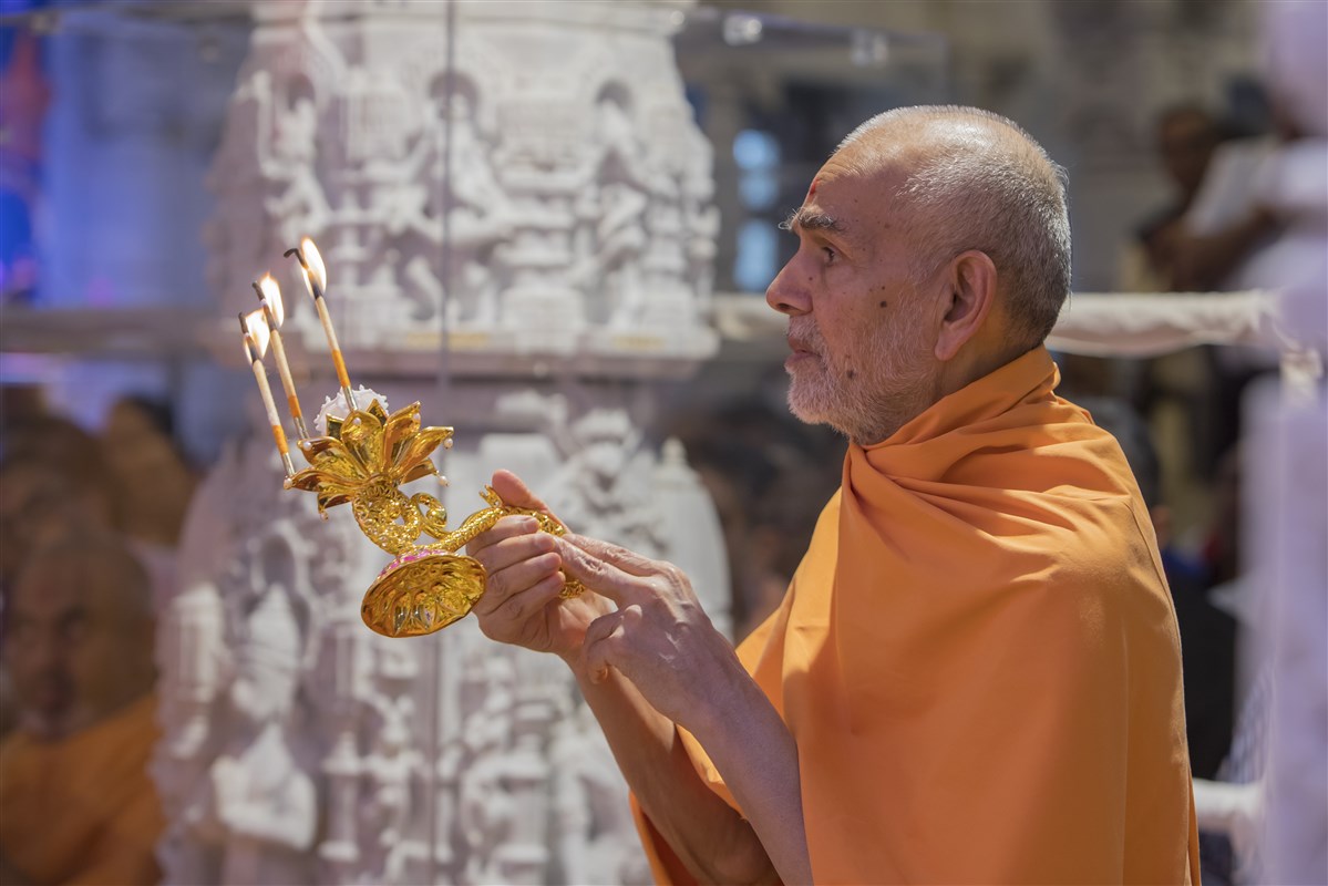 Swamishri performs the rajbhog arti of the central shrine murtis