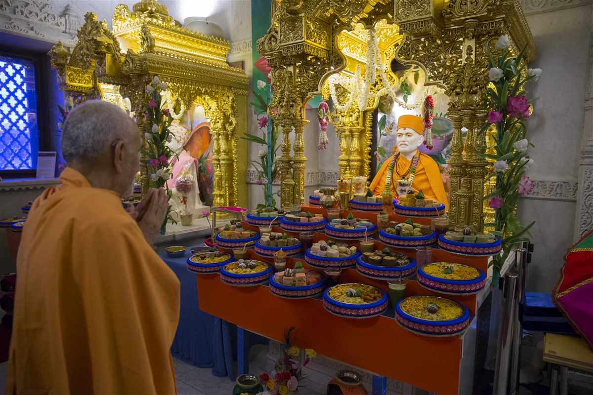 Swamishri engrossed in the annakut offering to the Guru Parampara