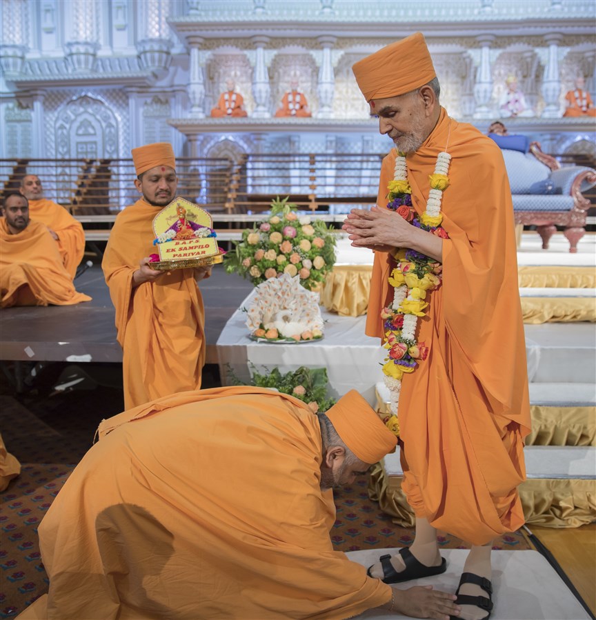 Yogvivekdas Swami bows before Swamishri after honouring him with a garland