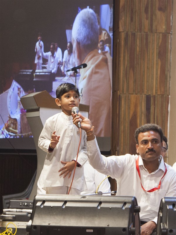 A child presents before Swamishri in his morning puja