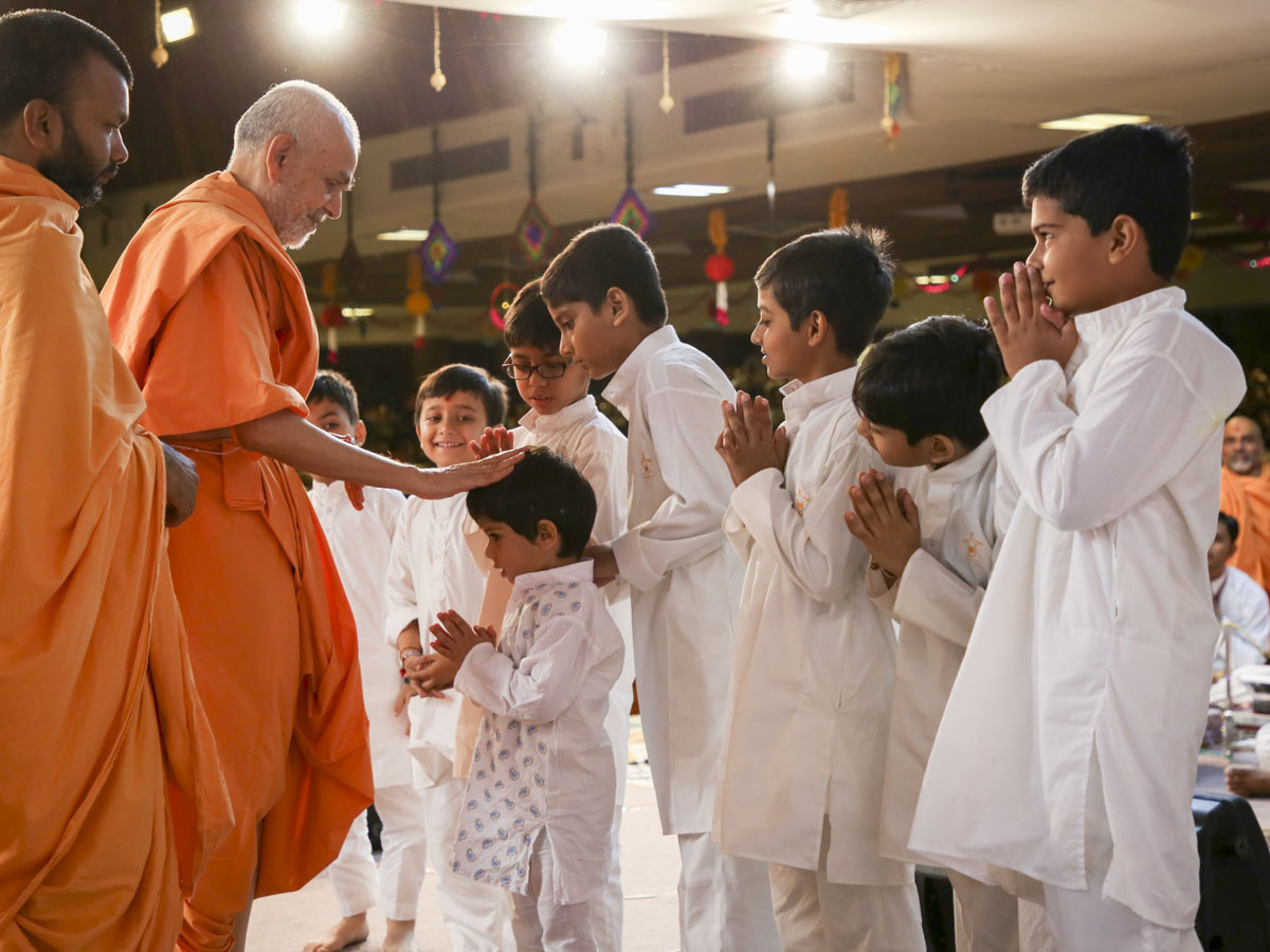 Swamishri blesses children who presented in his morning puja