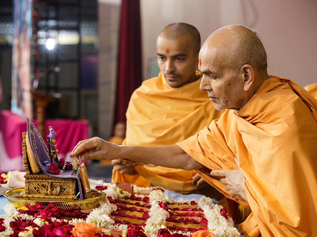Swamishri reverentially touches charanarvind of Shri Harikrishna Maharaj