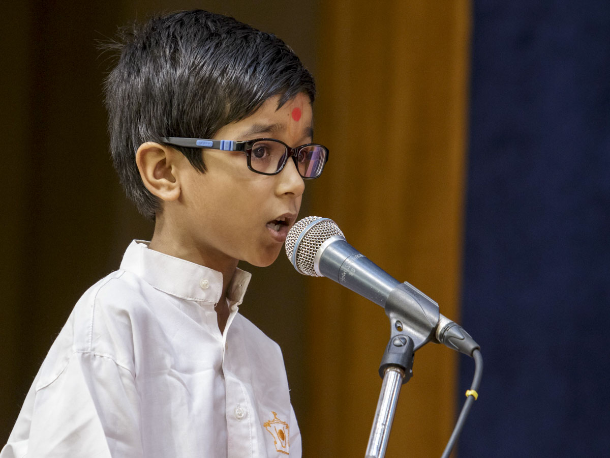 A child presents in Swamishri's puja