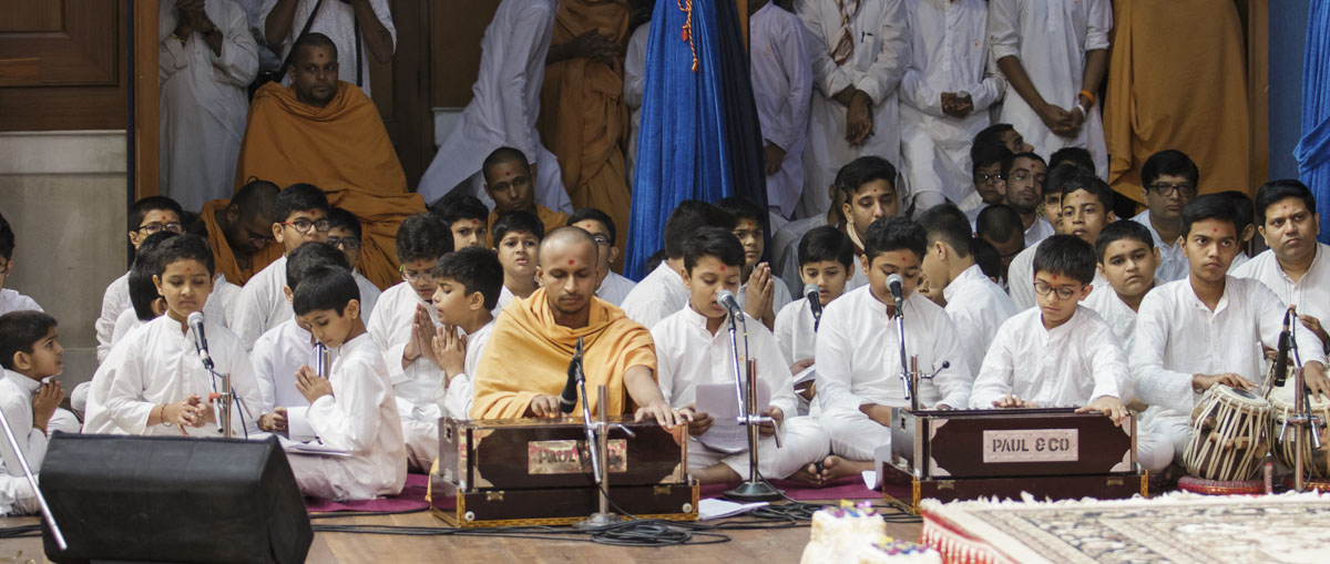 Children sing kirtans in Swamishri's puja