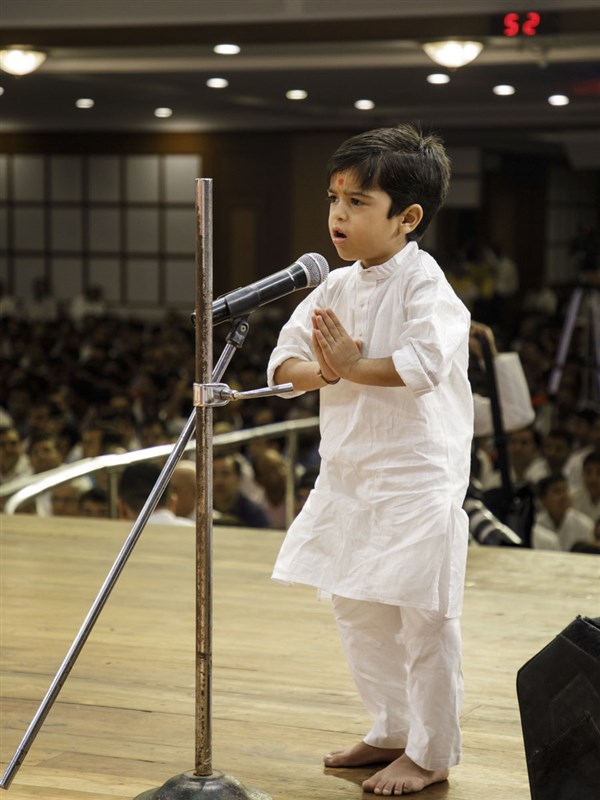 A child prays before Swamishri