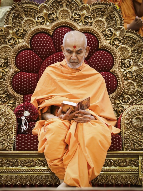 Swamishri reads the Shikshapatri during his morning puja