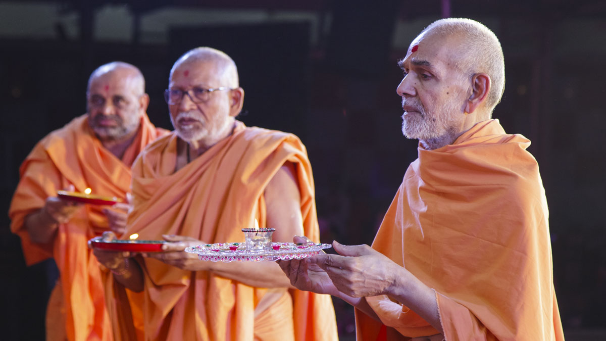 Swamishri, Pujya Kothari Swami and Bhagwatcharan Swami perform arti