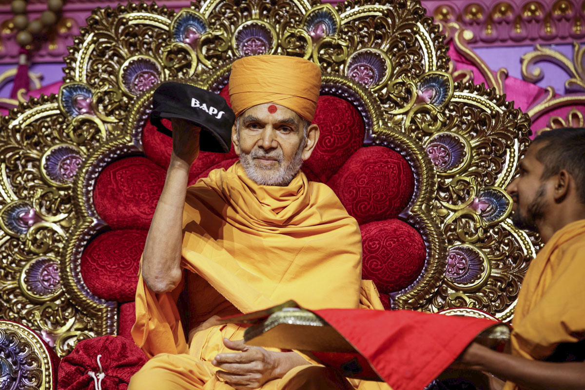 Swamishri sanctifies a cap