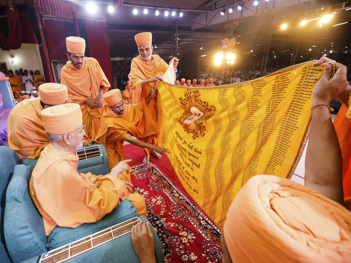 Swamishri sanctifies a shawl 