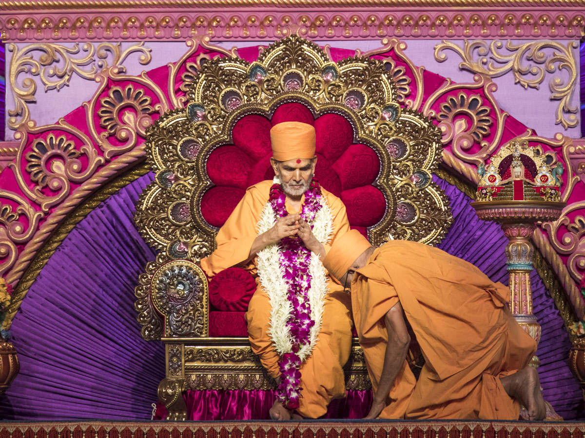 Pujya Kothari Swami honors Swamishri with a garland