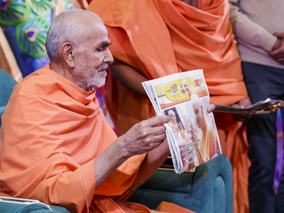 Swamishri sanctifies a special supplement in honor of Pramukh Swami Maharaj's birthday published by 'Divya Bhaskar'