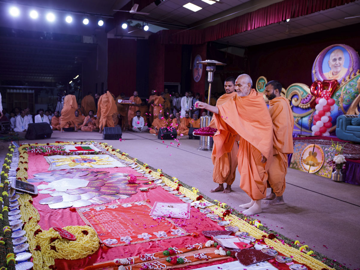 Swamishri sanctifies greeting cards and garlands prepared by devotees in celebration of Pramukh Swami Maharaj's birthday