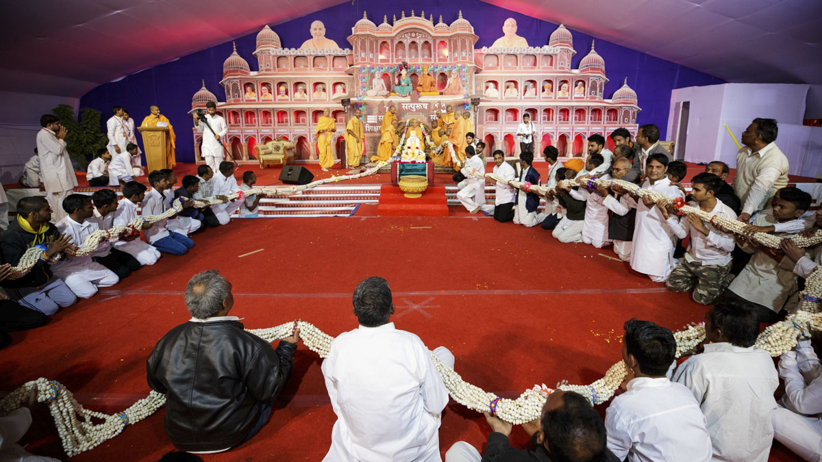Sadhus and karyakars honor Swamishri with a garland