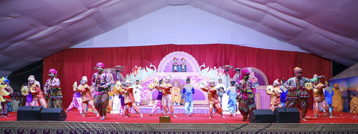 Children and youths perform a welcome dance before Swamishri