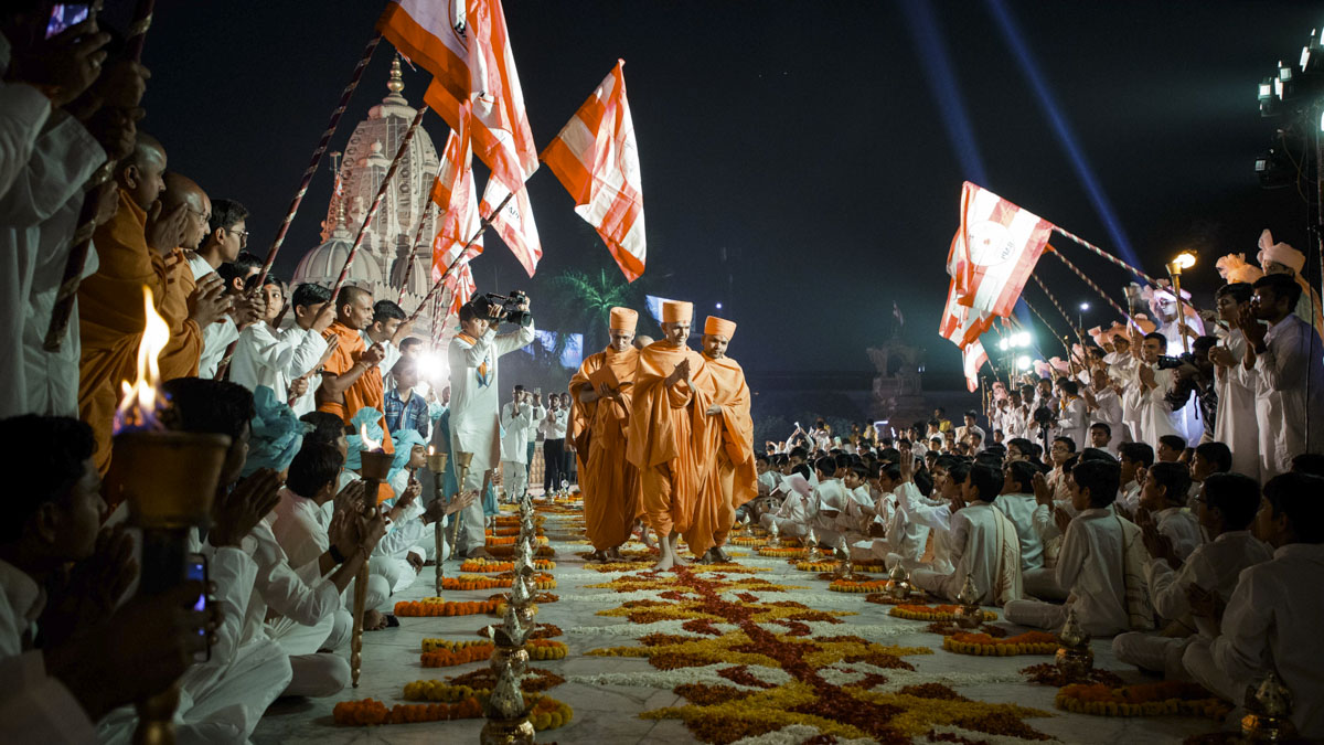 Devotees welcome Swamishri with BAPS flags