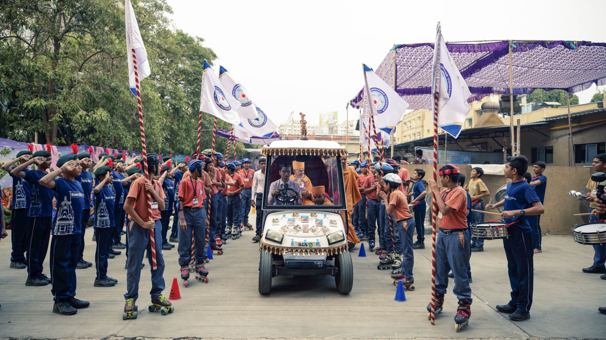Students of Swaminarayan Vidyamandir lead Swamishri to the school