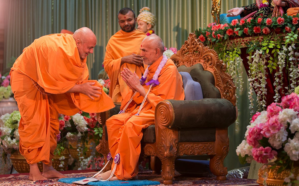 Pujya Viveksagar Swami honors Swamishri with a garland