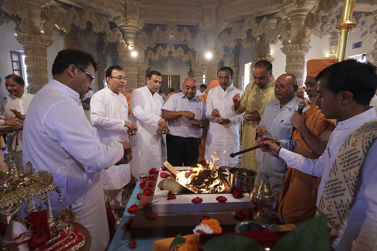 Devotees participate in the Vastu Hom rituals