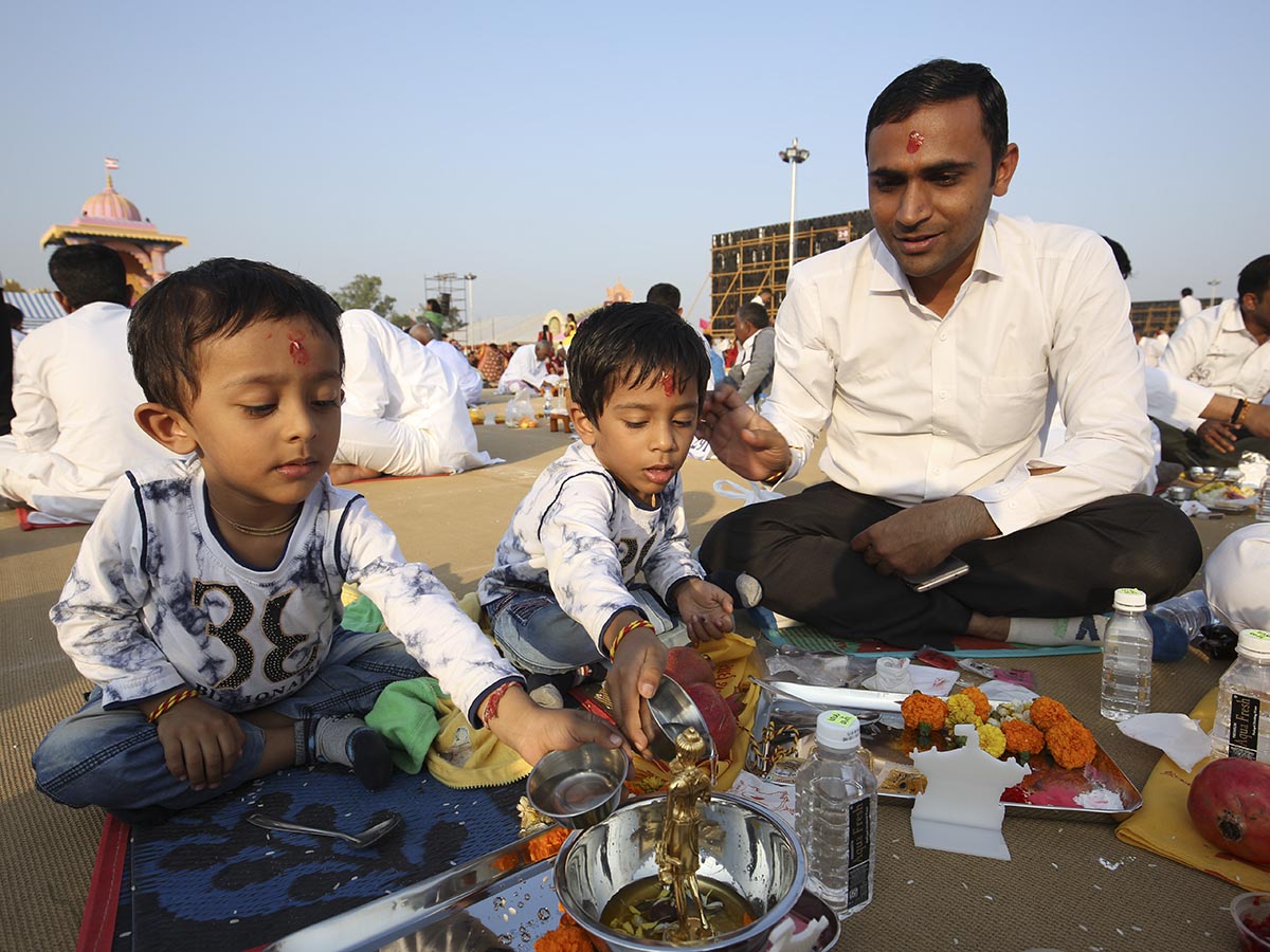 Children and a devotee participate in the mahapuja rituals