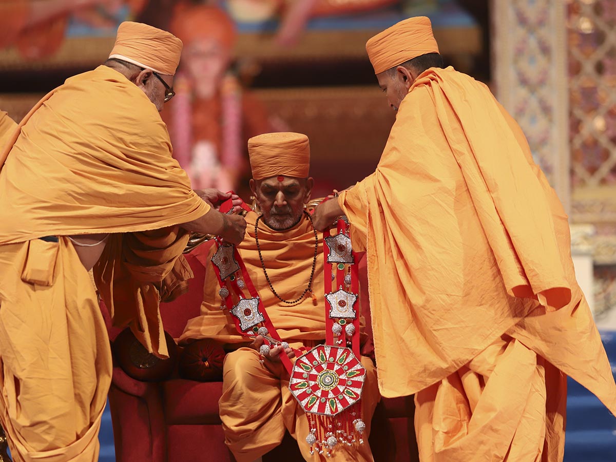 Gnanprasad Swami and Divyapurush Swami honor Swamishri with a garland