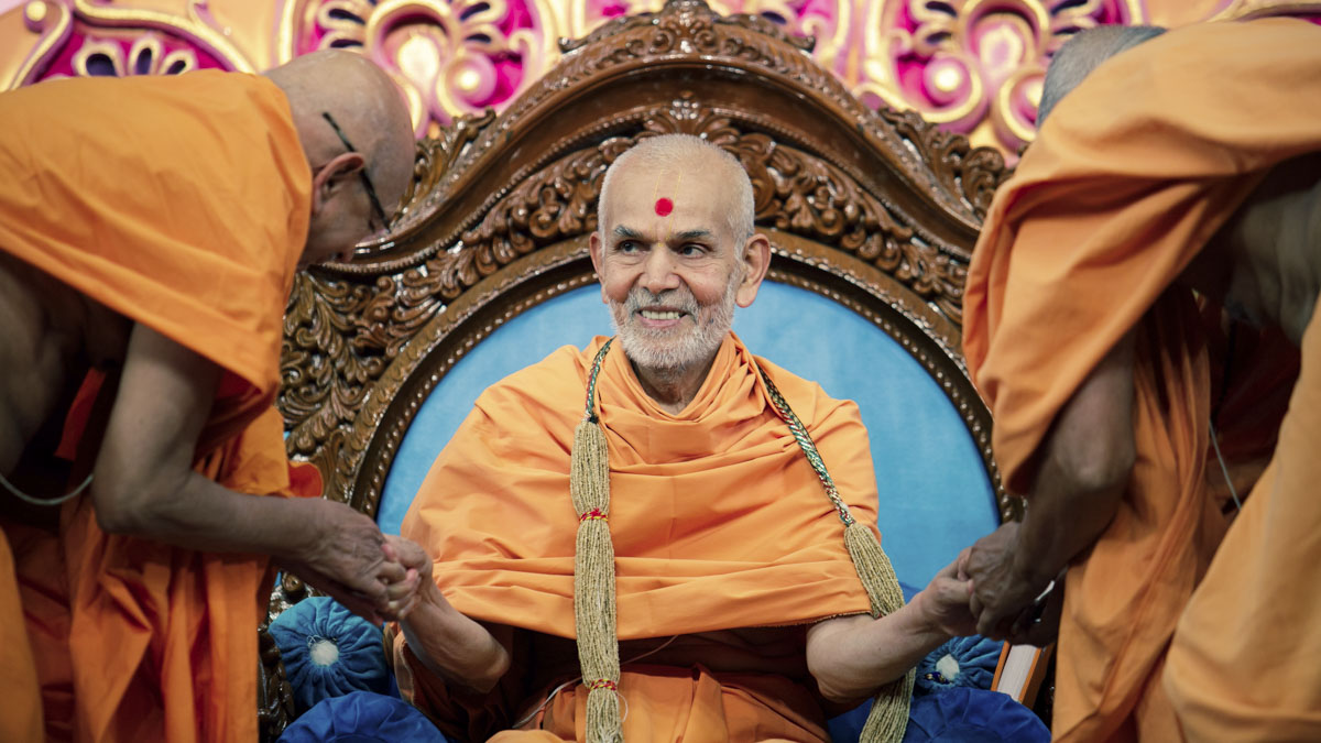 Pujya Tyagvallabh Swami and Pujya Kothari Swami honor Swamishri with a garland