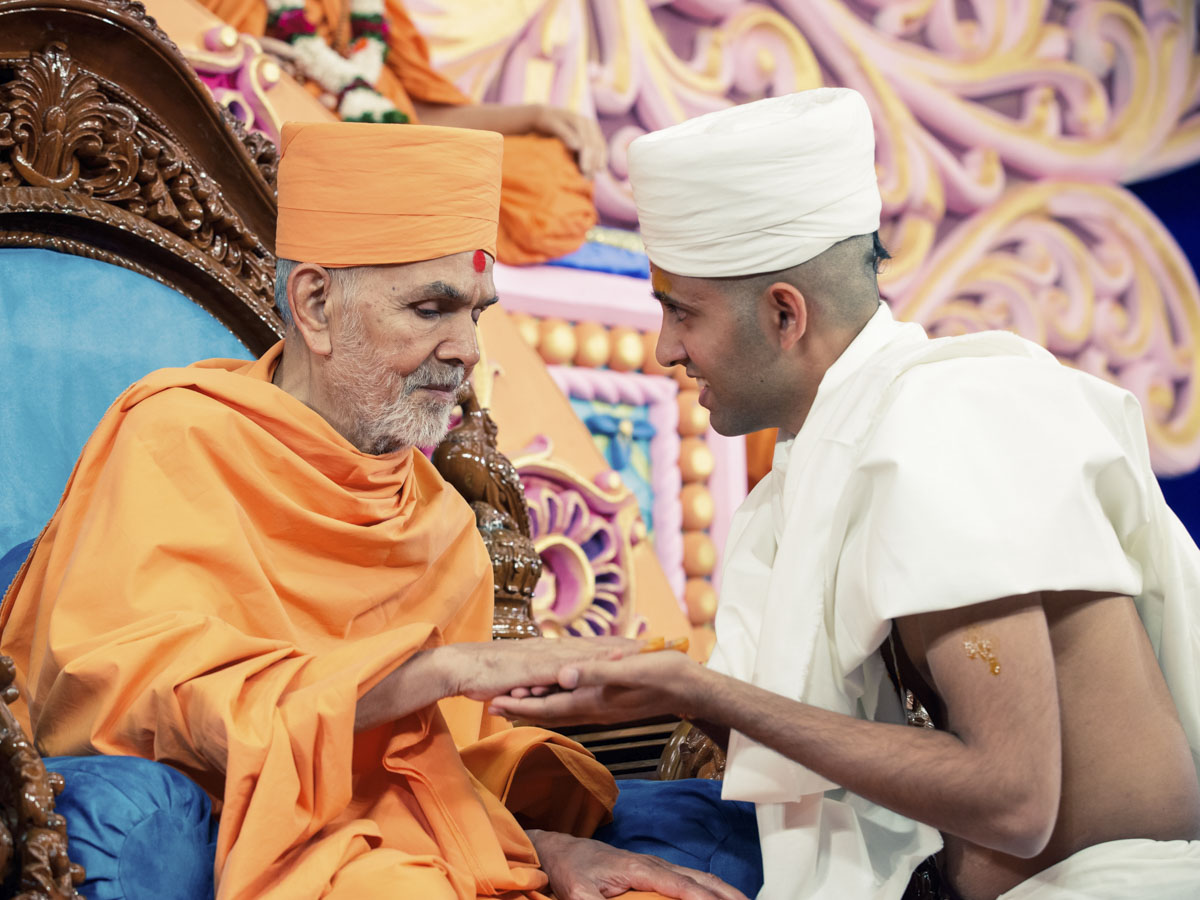 Swamishri gives diksha mantra to newly initiated parshads and blesses them