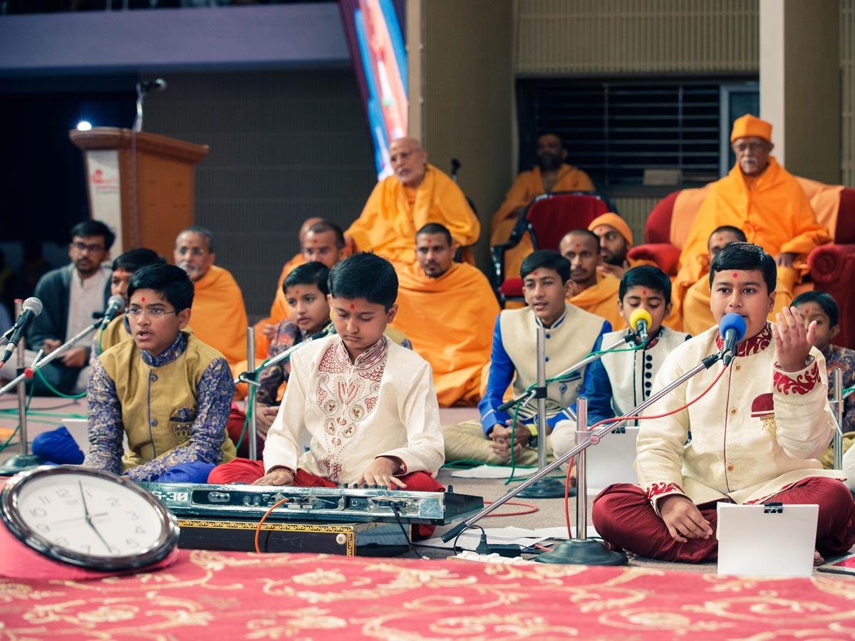 Students of Swaminarayan Vidyamandir sing kirtans in Swamishri's morning puja
