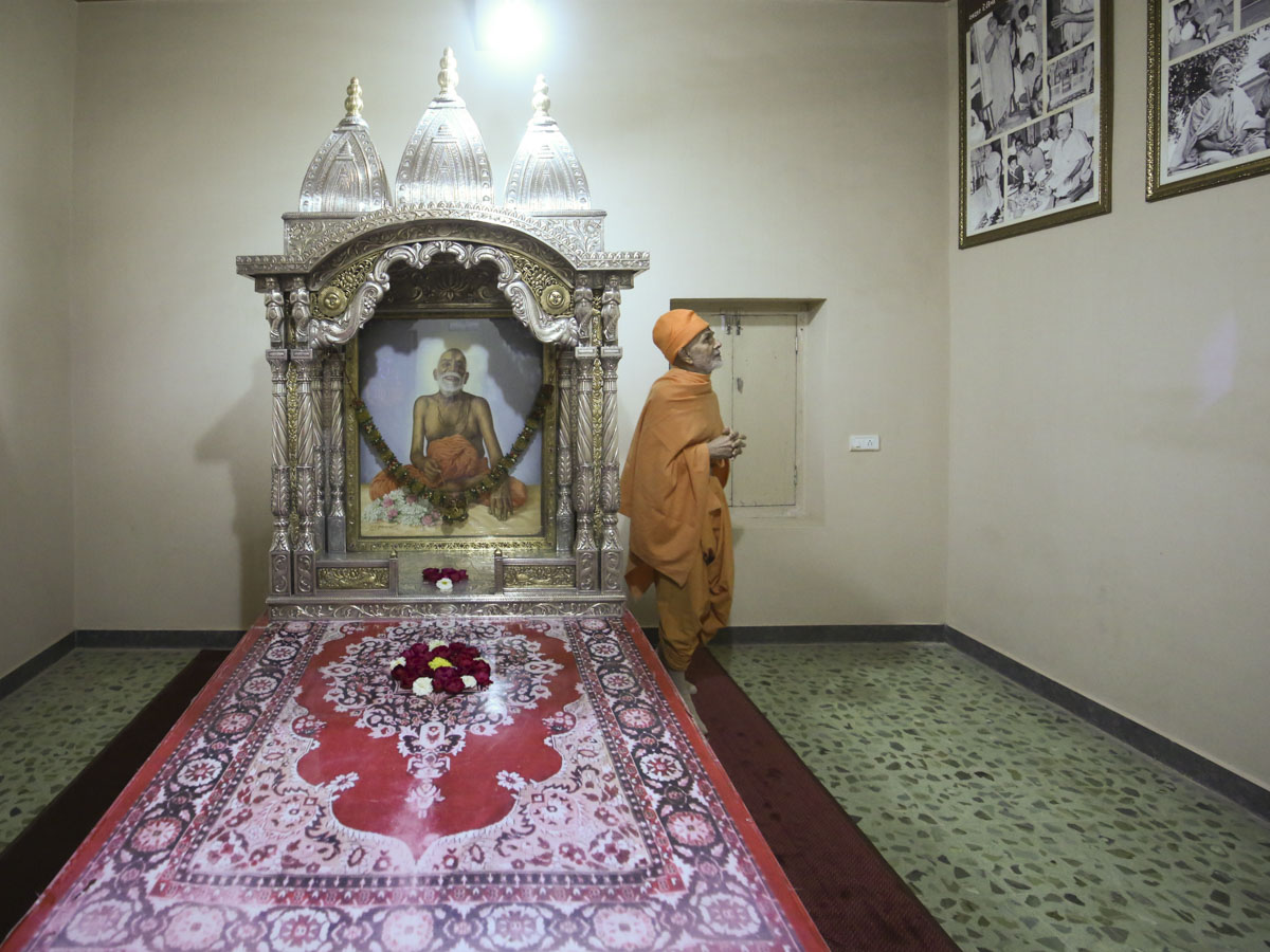 Param Pujya Mahant Swami Maharaj observes a photo in Brahmaswarup Yogiji Maharaj's room