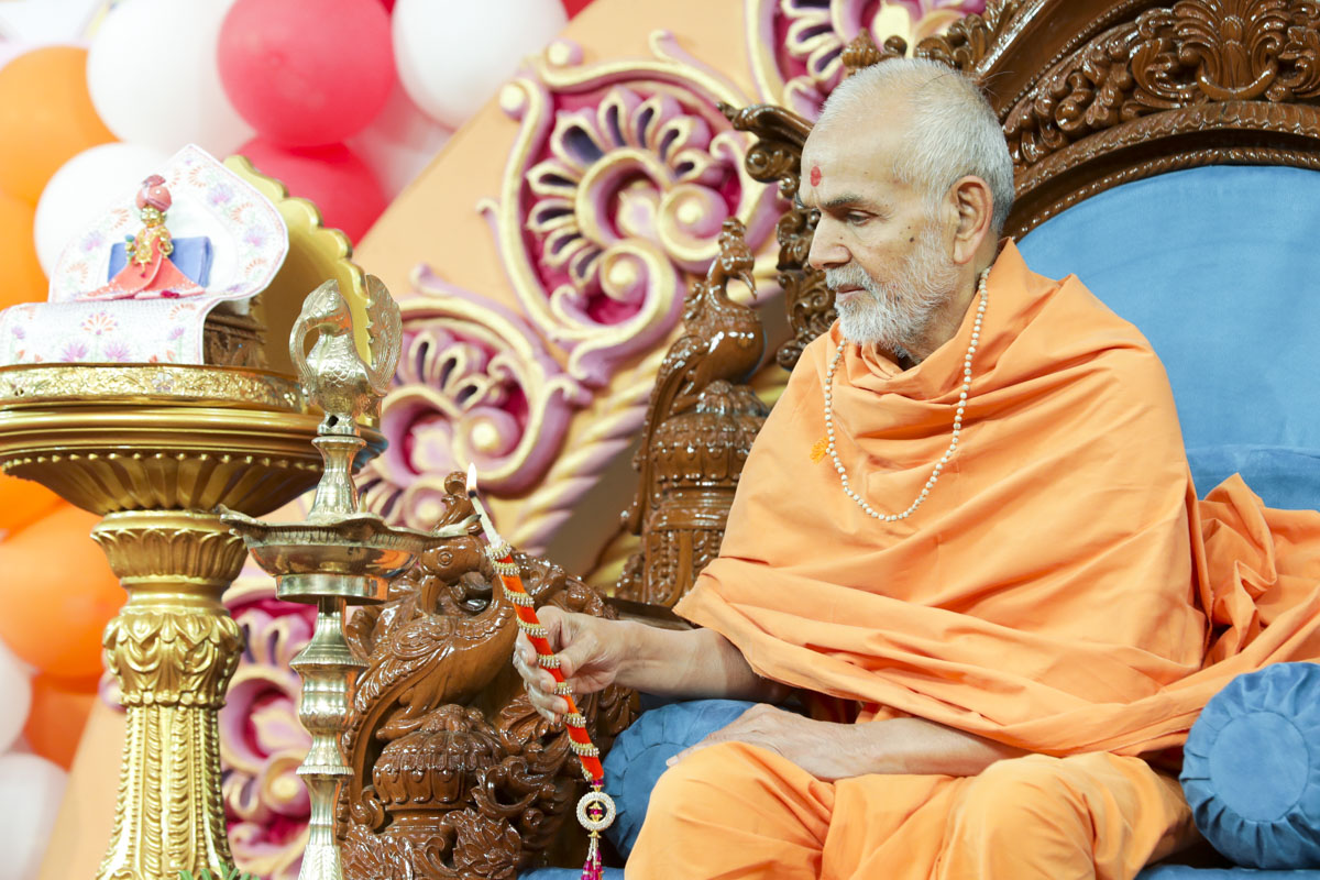 Swamishri lights the lamp to inaugurate the 98th birthday celebrations of Brahmaswarup Pramukh Swami Maharaj, to be held in Rajkot