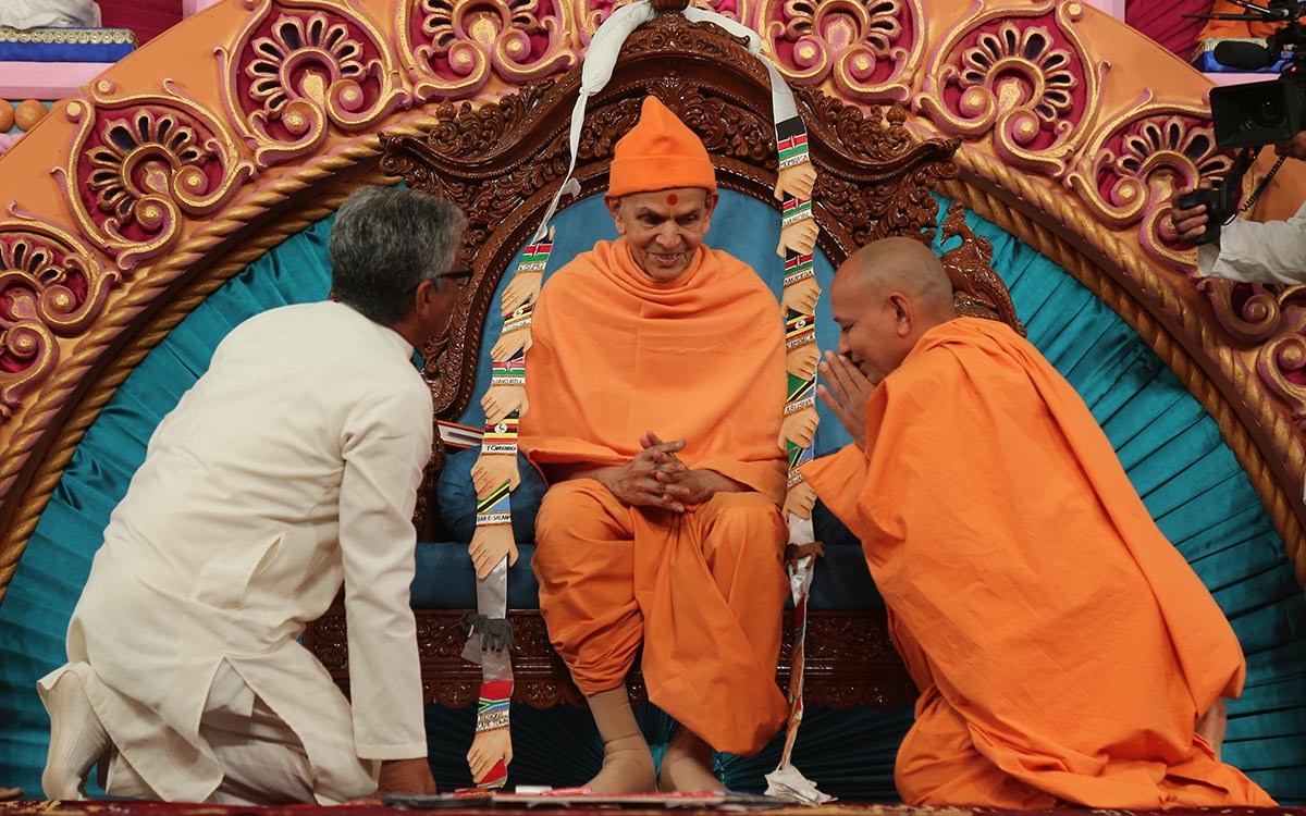 Divyapurush Swami and Shri Nirmalsinh Rana honor Swamishri with a garland