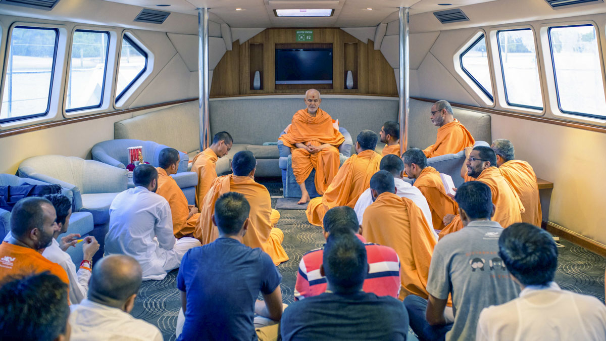 Swamishri on the boat with sadhus and devotees