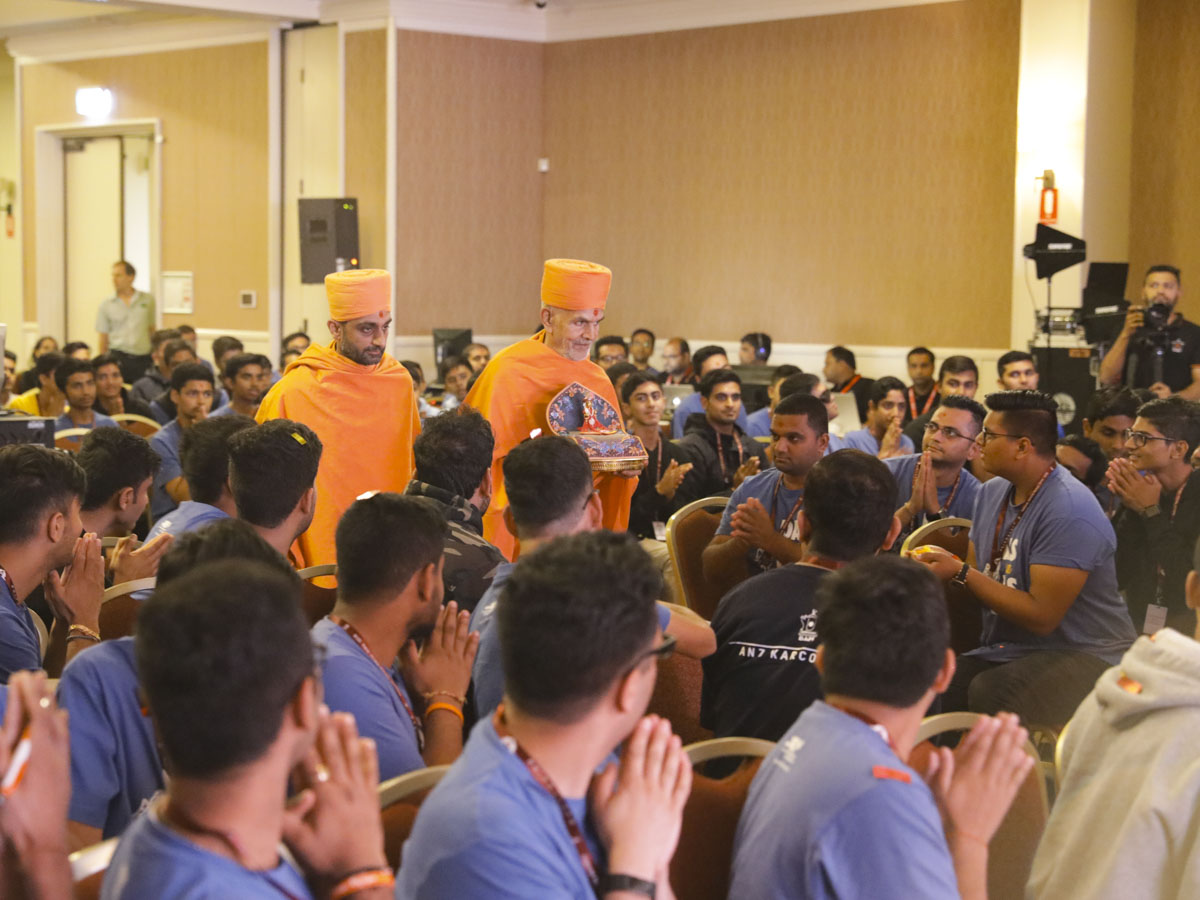Swamishri arrives in the convention hall with Shri Harikrishna Maharaj