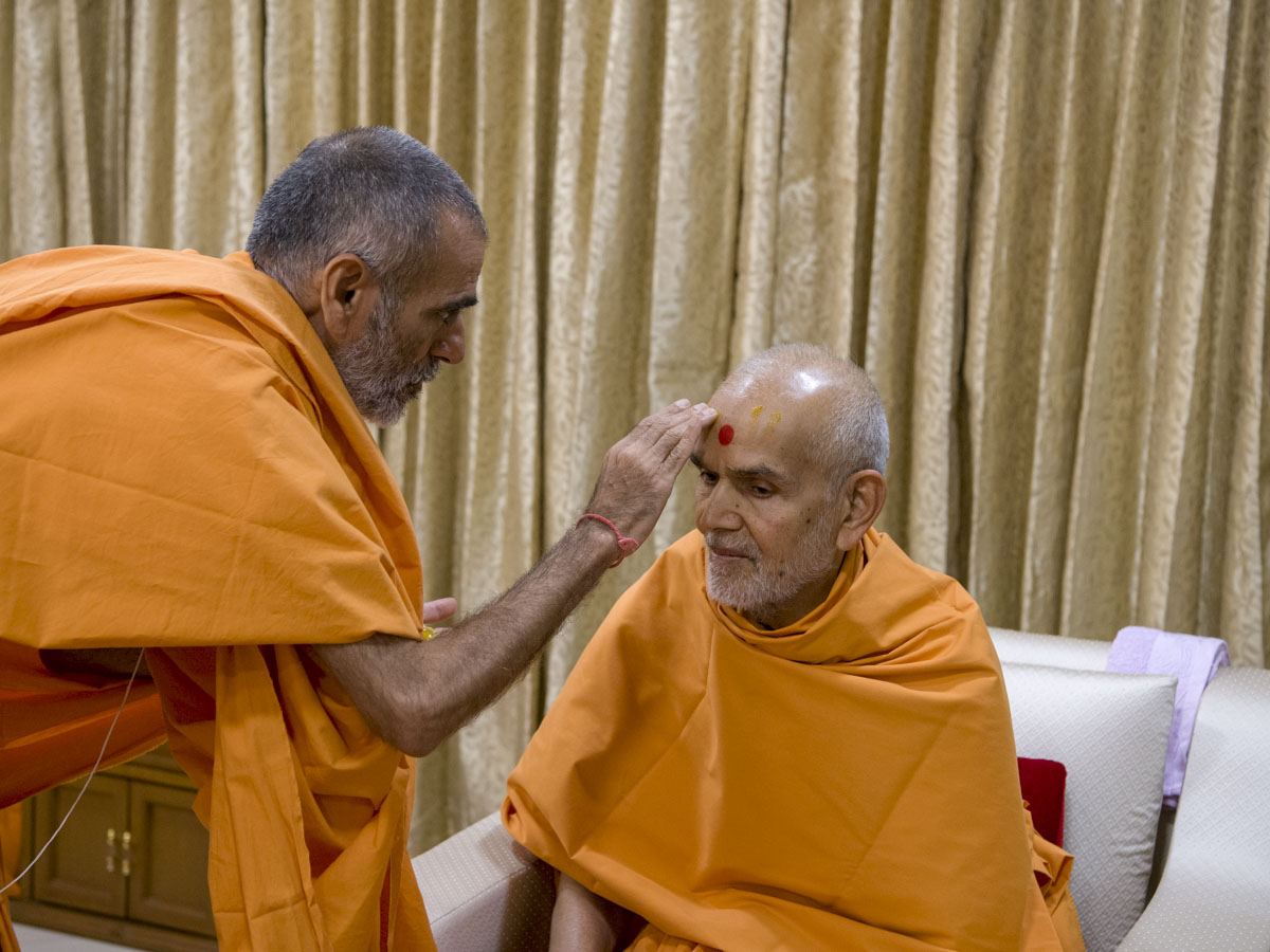 Anandswarup Swami applies chandan to Swamishri