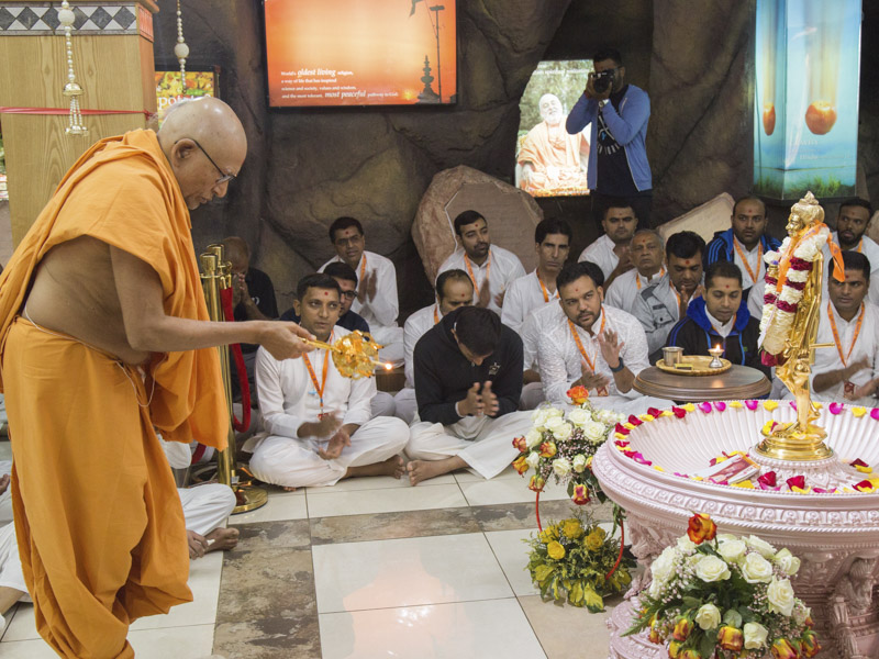 Pujya Kothari Swami performs the morning arti