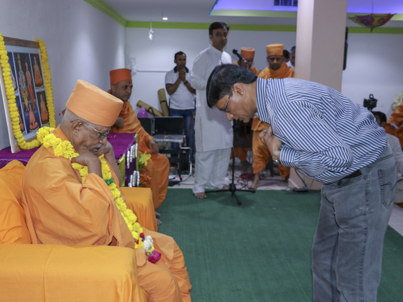 Devotees welcome Pujya Doctor Swami with a garland