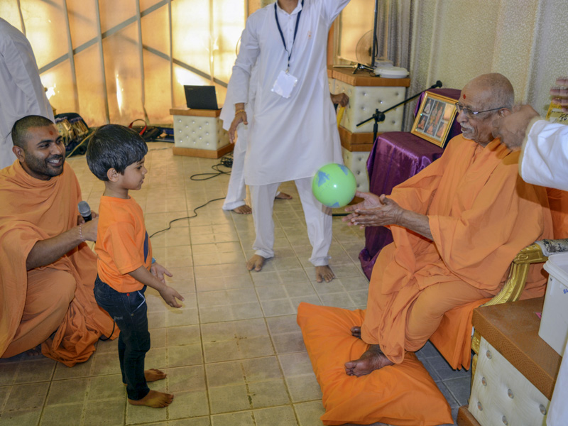 A child interacts with Pujya Doctor Swami