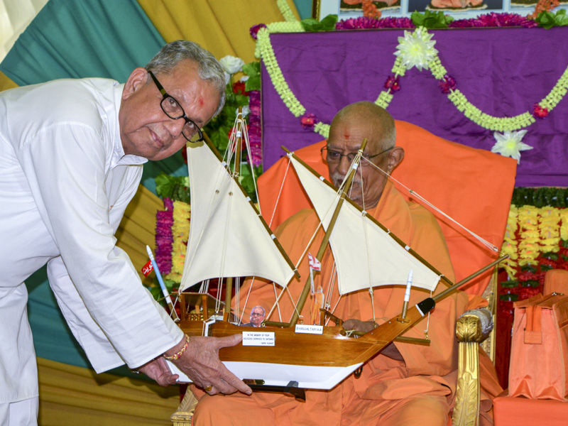 A devotee presents a memento to Pujya Doctor Swami